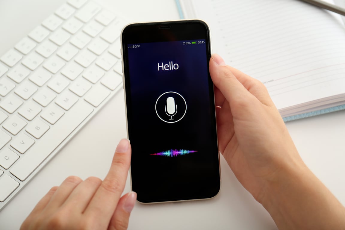 Woman Using Voice Search on Smartphone at White Table, Closeup